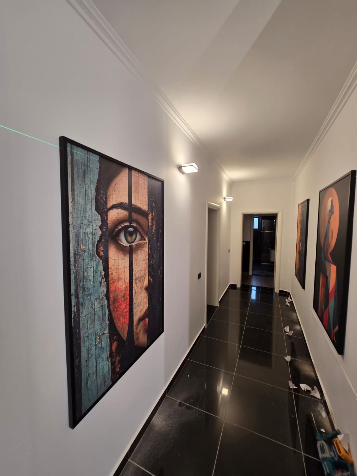 Korniza printimesh duke u vendosur në korridor me vijë laser në mur