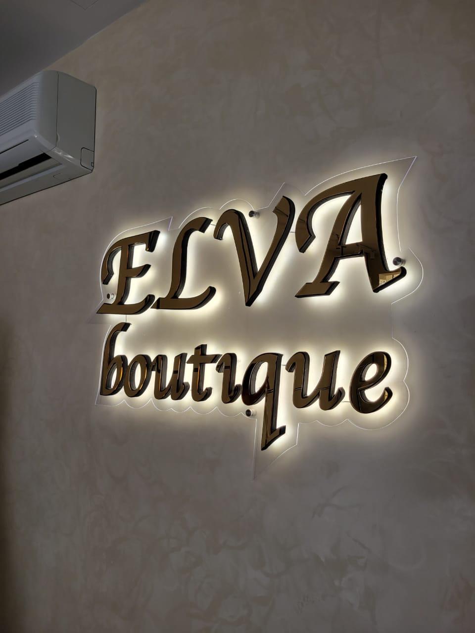 Shkronja pasqyrë ari ELVA boutique me ndriçim të ngrohtë halo në murin e dyqanit