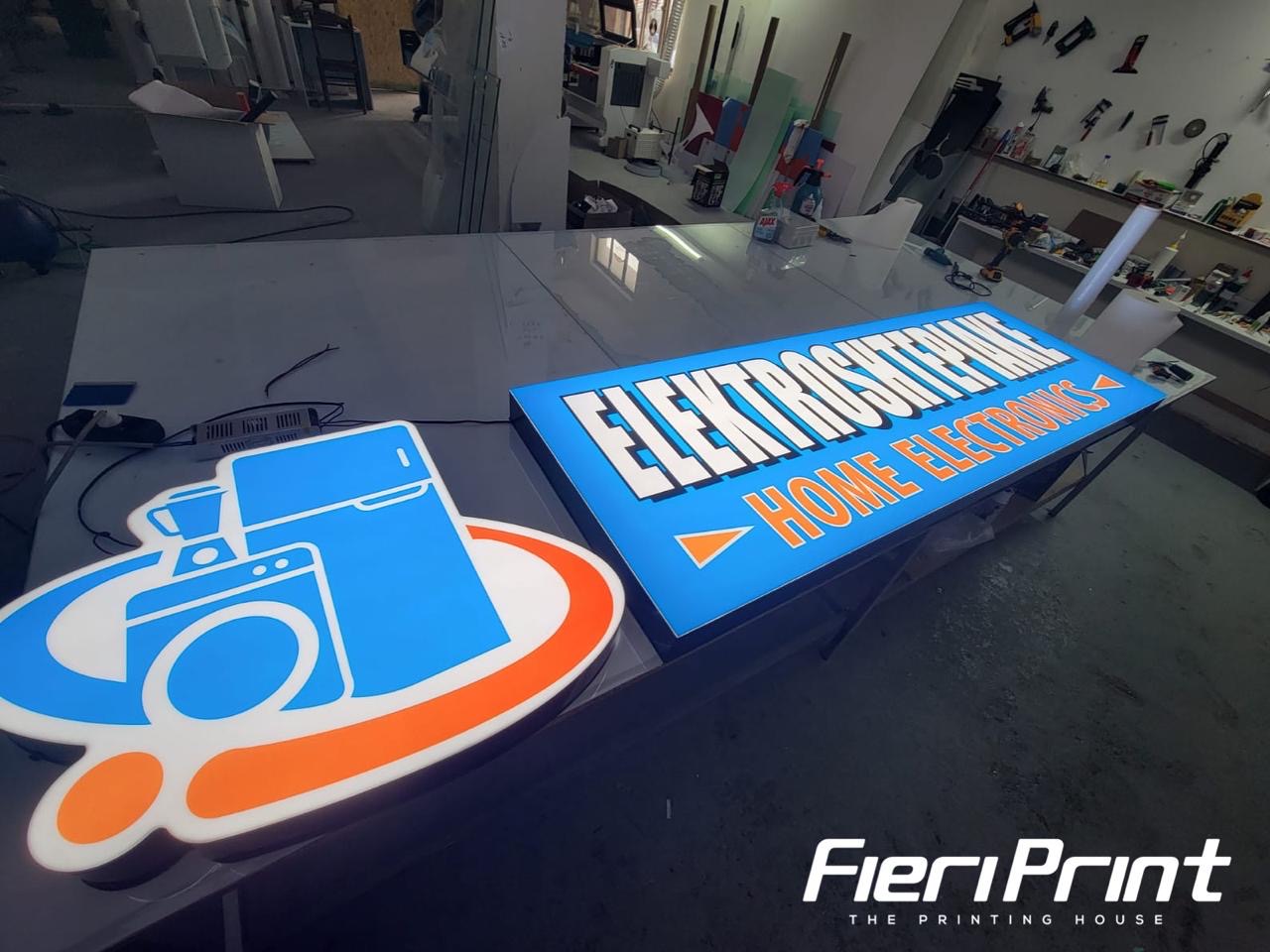 Lightbox blu Elektroshtëpiake dhe logo e prerë me formë elektroshtëpiakesh, të ndezura në studio
